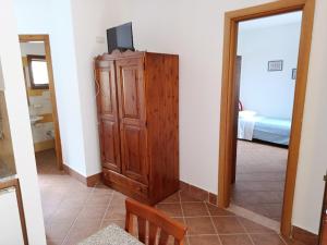 a room with a tv on top of a wooden cabinet at Accomodation Villa Florio Parghelia in Fitili