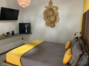 a bedroom with a bed and a tv on a wall at Jardim dos Milagres Suítes in São Miguel dos Milagres