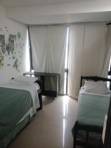 a bedroom with two beds and a desk and windows at Casa calle San José in Gualeguaychú