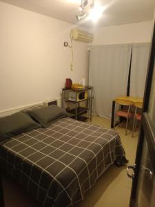 a bedroom with a bed and a table and a desk at Casa calle San José in Gualeguaychú