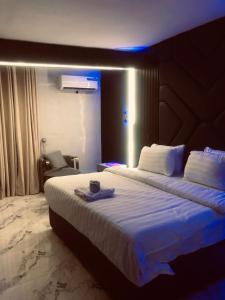a hotel room with a large bed with a blue light at Kim Royal Hotel and Suites in Festac Town +7 photos