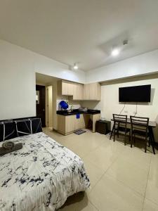 a bedroom with a bed and a kitchen with a flat screen tv at Mabolo Garden Flats 2312 in Cebu City +9 photos