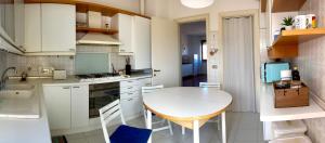 a small kitchen with a white table and chairs at ZENIT Rooms in Senigallia