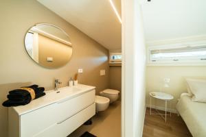 a bathroom with a sink and a toilet and a mirror at Relais Lungolago Gavirate in Gavirate