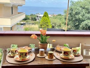 Ein Tisch mit Kaffeetassen und Gebäck auf einem Balkon in der Unterkunft Tropea Casa Scirocco in Tropea
