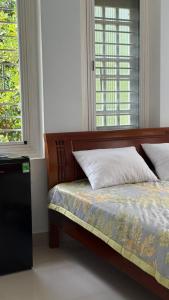 a bedroom with a bed and two windows at Vy Home in Thanh Ðông (1) +11 photos