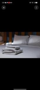 Zwei Handtücher liegen auf einem weißen Bett. in der Unterkunft Little base hotel in Ale