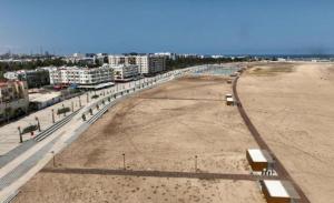 a large empty beach with buildings in the background at Studio Appartement MIRAMAR in Mohammedia