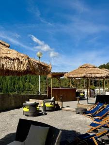 a patio with lounge chairs and straw umbrellas at Adrechas Mercantour in La Colmiane