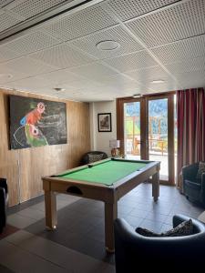 a room with a pool table and a painting on the wall at Adrechas Mercantour in La Colmiane