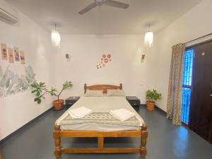 a bedroom with a bed in a room with plants at Casa de sazu 1bhk in Mandrem