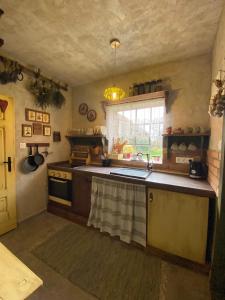 a kitchen with a sink and a stove and a window at Chalupa u babičky in Salka