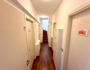 a hallway with white walls and wooden floors at ZENIT Rooms in Senigallia +16 photos