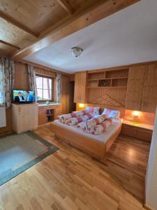 a bedroom with a large bed and a television at Orterhof in Obertilliach