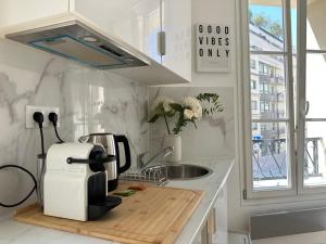a kitchen with a coffee maker on a counter at Hôtel My Suite Paris in Paris