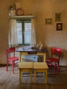 a table with two red chairs and a table with a bench at Chalupa u babičky in Salka +4 photos
