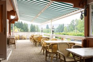 an empty patio with tables and chairs in a restaurant at Arden Parks Petite Suisse in Dochamps +10 photos