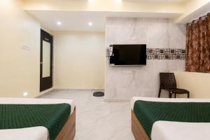 a room with two beds and a flat screen tv at Hotel Platinum in Mumbai +15 photos