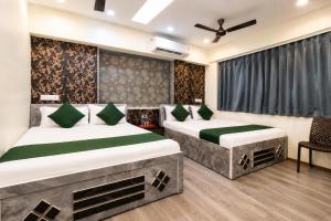 a bedroom with two beds and a window at Hotel Platinum in Mumbai