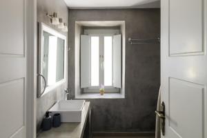 a bathroom with a white sink and a mirror at Kamares Neoklassiko in Fira +62 photos