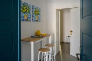a kitchen with a counter and stools in a room at Kamares Neoklassiko in Fira