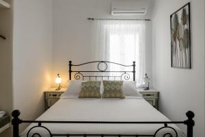 a bedroom with a bed with a black frame and a window at Kamares Neoklassiko in Fira
