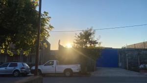 a white truck parked in a parking lot with the sunset at Carlos, el alojamiento in Mercedes