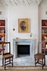 a living room with a fireplace and two chairs at Hotel Boutique Casa Treviño in Campo de Criptana