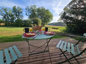 ein Tisch mit Tellern mit Essen und zwei Stühlen in der Unterkunft L' Ecrin in Auch