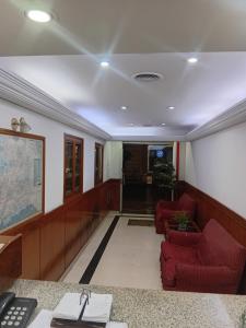 a living room with red chairs and a desk at Hotel guido palace in Buenos Aires +2 photos