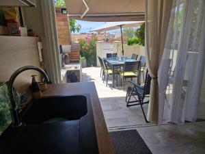a patio with a table and chairs and an umbrella at Nouveau ! Maison Dora 4-6 pers à St Pierre La Mer proche de la plage et de toutes commodités à pied in Saint Pierre La Mer