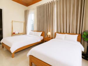 a bedroom with two beds and a window at May Garden Home in Da Lat