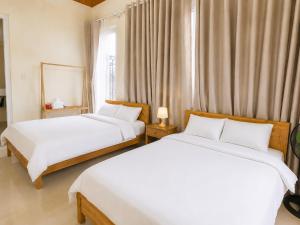 a bedroom with two beds and a window at May Garden Home in Da Lat
