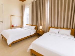 a bedroom with two beds and a window at May Garden Home in Da Lat