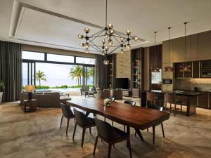 a dining room and living room with a table and chairs at Mövenpick Villas & Residences Phu Quoc in Phú Quốc