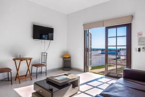 a living room with a couch and a tv at Dog-Friendly Beach Haven with Heated Pool, Hot Tub, Kitchenette, Patio, AC in Rosarito