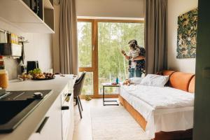 a woman standing in a kitchen with a bed in a room at Sume by Larsen in Tallinn