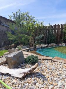 a swimming pool with rocks and a fence at Chalupa u babičky in Salka