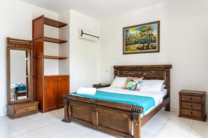 a bedroom with a wooden bed and a mirror at Olas del Mar Hotel by GHO Hoteles in Santa Marta