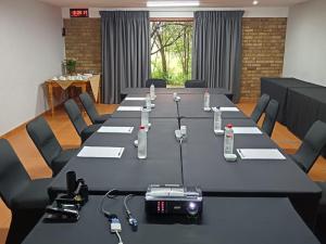 a conference room with a long table with phones on it at Airport Bird & Game Lodge in Kempton Park