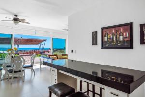 a kitchen with a bar with a table and chairs at Bright Dog-Friendly Villa with Beach Views, Private Patio, Outdoor Pool, Kitchen in Rosarito