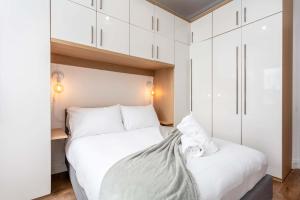 a bedroom with a white bed and white cabinets at Scott Suite - Donnini Apartments in Kilmarnock