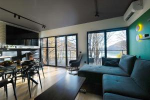 a living room with a blue couch and a table at Paltinu Lake Villas in Teşila