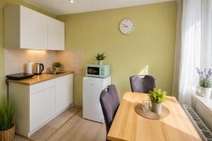a kitchen and dining room with a table and a clock on the wall at Apartment Hotel in Nuremberg