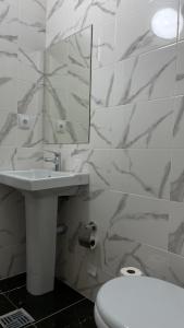 a bathroom with a sink and a toilet and a mirror at Ак-Кеме отель in Bosteri +25 photos