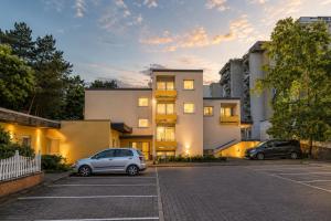 two cars parked in a parking lot in front of a building at Apartment Hotel in Nuremberg