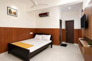 a bedroom with a bed and a flat screen tv at Tabish INN in Trivandrum