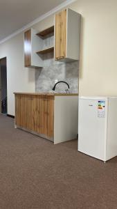 a kitchen with a sink and a refrigerator at Ак-Кеме отель in Bosteri