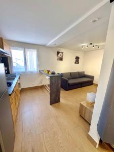 a kitchen and living room with a couch and a table at Studio avec Wi-Fi, à 5mn de la Centrale du Bugey in Loyettes