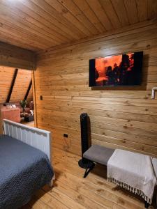 a bedroom with a bed and a tv on a wall at Alpina Village, Jacuzzi Climatizado, Montaña, Fogata, Jarabacoa in Jarabacoa +30 photos